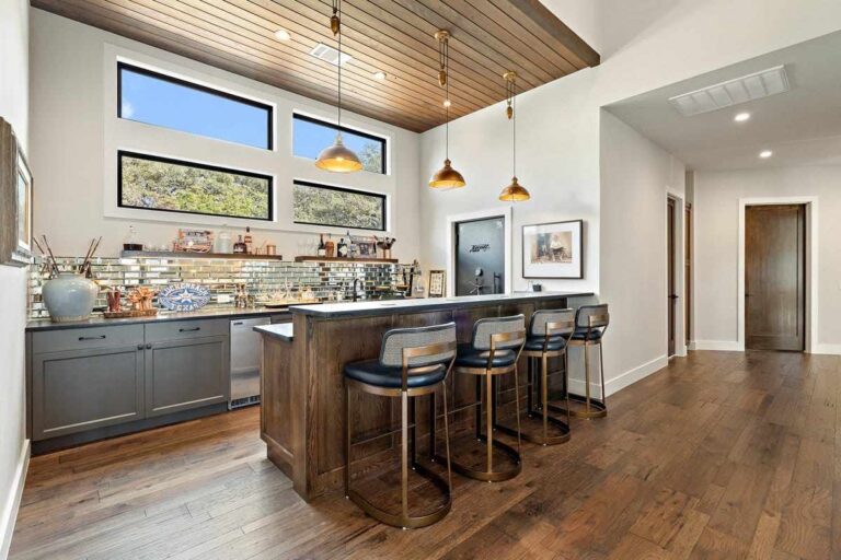 Contemporary kitchen complete with bar stools and a wooden ceiling in Texas